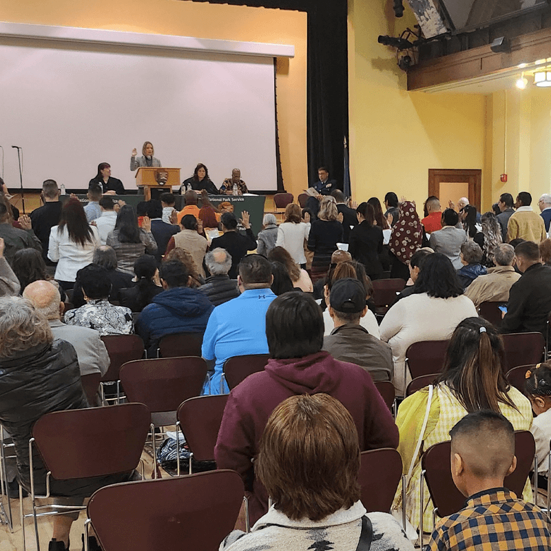 Group of individuals reciting the Oath of Allegiance with spectators watching the ceremony.